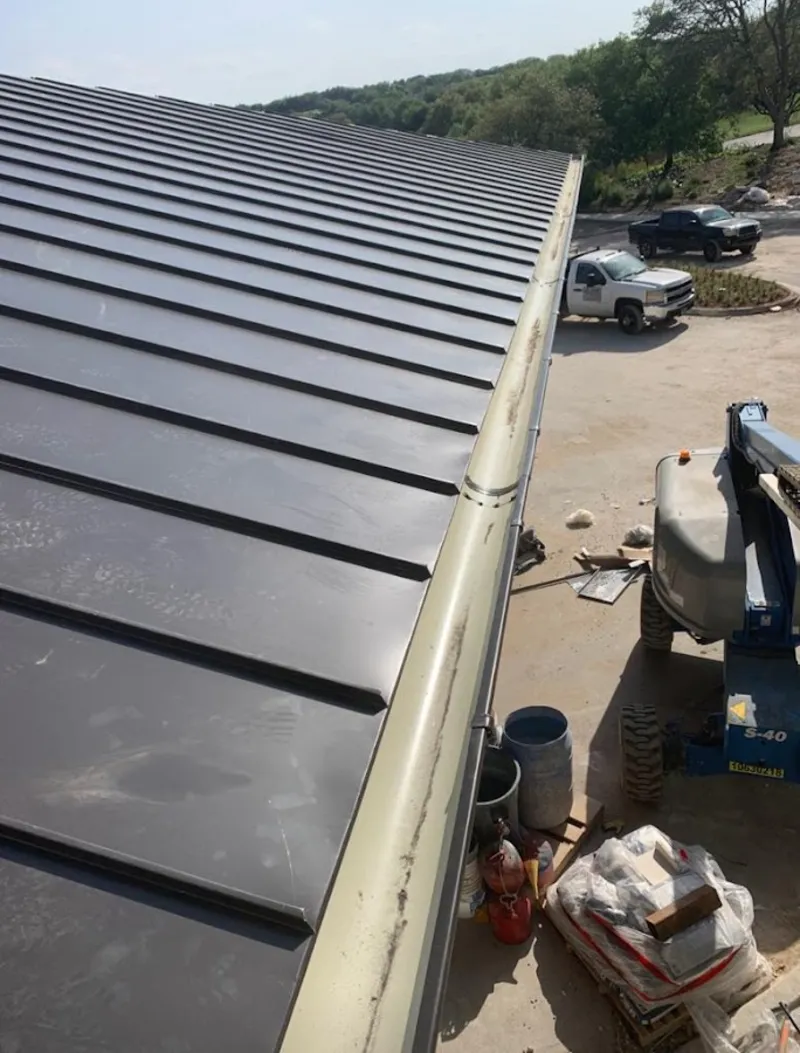 Standing seam panel and gutter detail on a metal roofing jobsite in Mabank